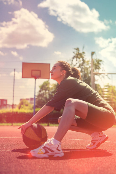 魅力的な若い女性は、バスケットボールとスポーツ布を着用ワークアウトの後に休んでいる。スポーツのための夏休み - 写真・画像