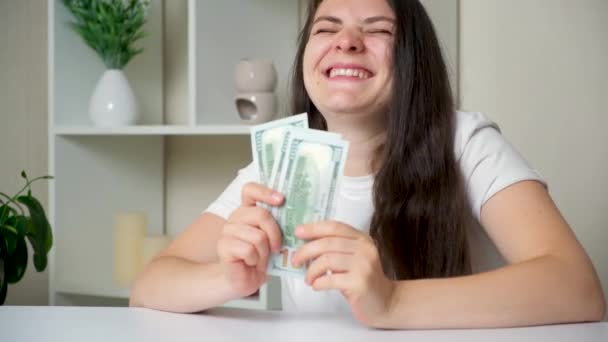 A beautiful woman of 30 years old counts bills for a hundred dollars and rejoices. - Materiaali, video