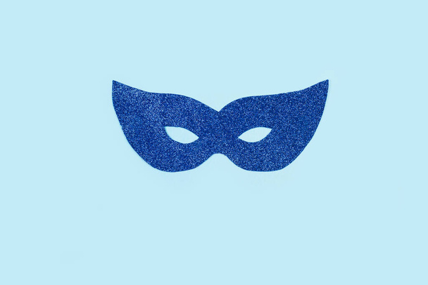 Blue party glitter eye mask on a light blue background with copy space - 写真・画像
