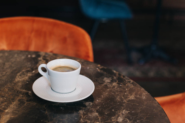 Cup of black coffee on a table in a cafe. Selective focus. Place for text. - Photo, Image