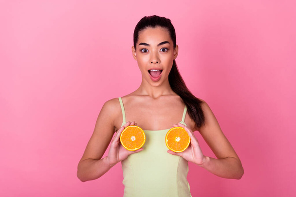 Photo of pretty impressed woman wear yellow dress holding citrus halves boobs open mouth isolated pink color background. - Fotoğraf, Görsel
