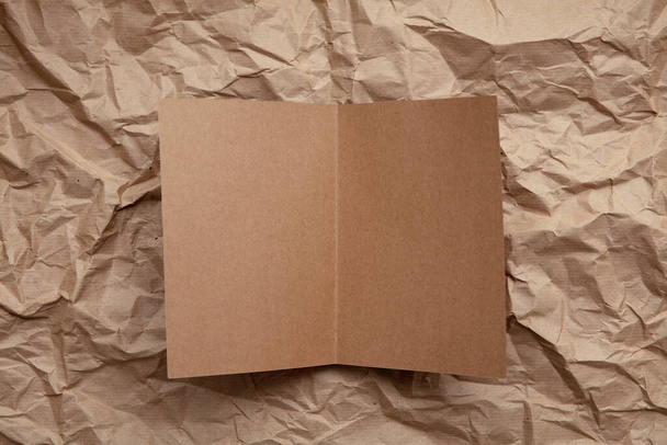 Blank invitation letter template mock up on crumpled brown paper. - Foto, imagen