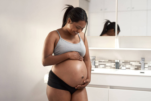 Happiness is carrying a whole world inside you. a pregnant woman in the bathroom at home - Foto, Imagem