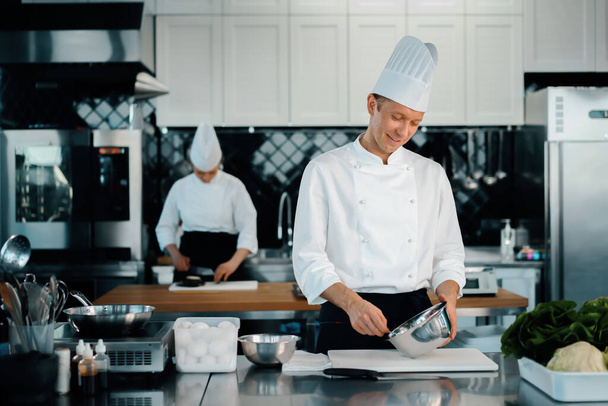 Professional restaurant kitchen: chefs prepare delicious dish - 写真・画像