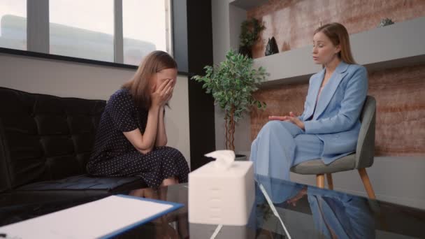 upset woman sitting on a couch crying telling about her problem meeting with psychologist - Imágenes, Vídeo
