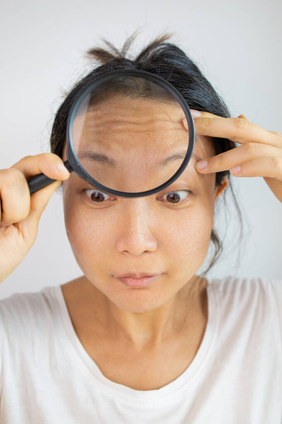 face asian woman forehead wrinkles face. aging skin on the forehead or crow's feet - Φωτογραφία, εικόνα