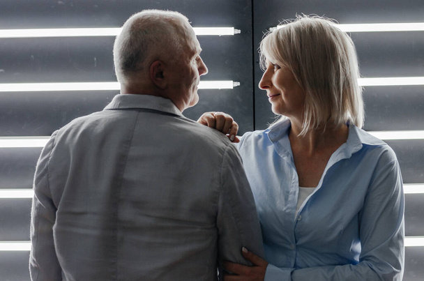 a man and a woman near a wall with backlight - Zdjęcie, obraz