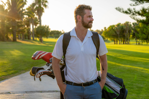 Golf ist ein Lebensstil. abgeschnittenes Bild eines männlichen Golfspielers, der Golftasche mit Fahrer bei Spaziergängen durch grünes Gras trägt - Foto, Bild