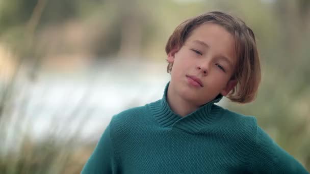 Portret van een tiener die in de camera kijkt en niest, buitenopname. Allergie of verkouden worden - Video