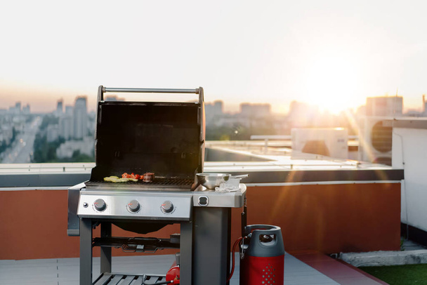 Skyscraper Rooftop: A professional male chef prepares barbecue at a party or outdoor restaurant. Grilled meat, vegetable - Valokuva, kuva