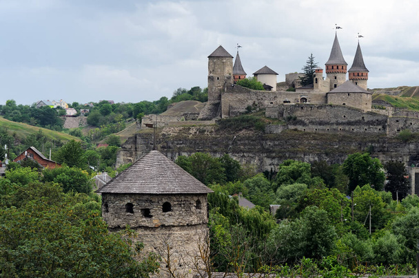 Old tower at background with Kamianets-Podilskyi Castle on background, Kamianets-Podilskyi, Ukraine - Zdjęcie, obraz
