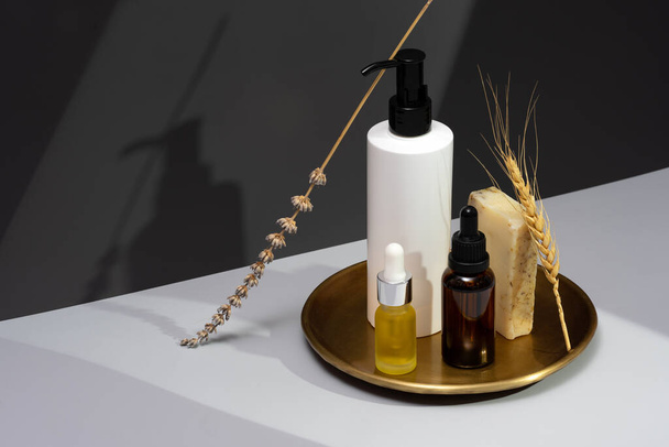 Set of essential oils, handmade soap and dried lavender on a dark gray background. Creative still life with natural cosmetics. The concept of selfcare and organic products. Isometric projection. - Photo, Image
