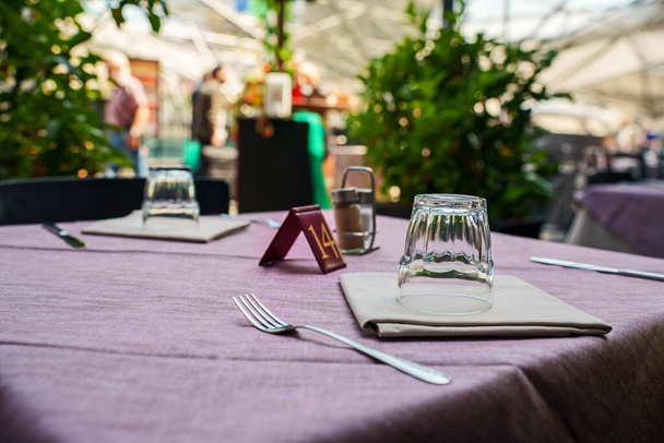 Table d'appoint avec vaisselle dans un restaurant moderne en été. - Photo, image