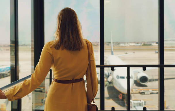 Жінка чекає свого польоту в аеропорту
. - Фото, зображення
