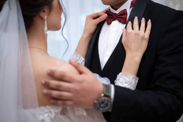 hands of the bride and groom on a bow tie on the wedding day. concept for wedding event agencie - Valokuva, kuva