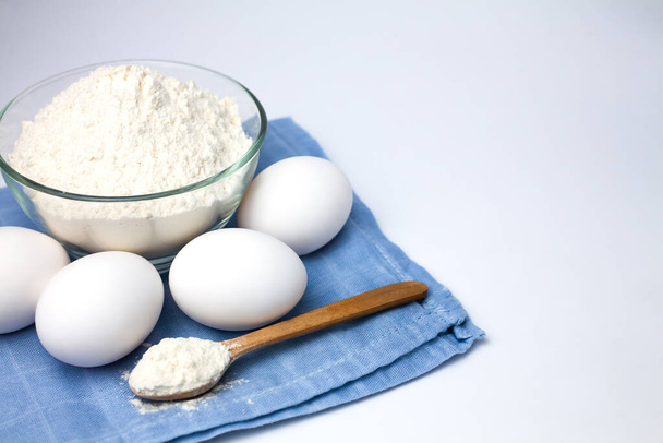 Ingredients for dough. Flour and eggs on the white background. Close-up. Copy space. - Foto, Imagem