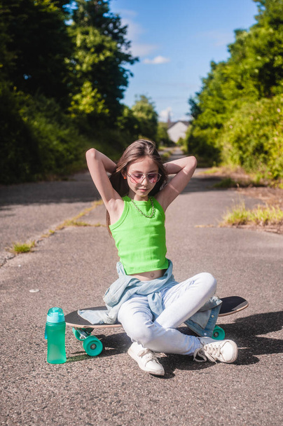young girl with her skateboard on a sunny day in the park - Fotó, kép