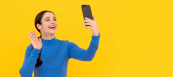 Жінка ізольована портрет обличчя, банер з копіювальним простором. щаслива дівчина жестикулює привіт на смартфон під час відеодзвінка, відеоблог
 - Фото, зображення