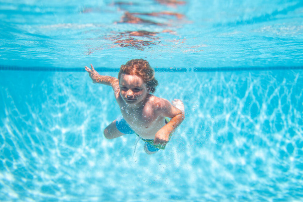 Underwater kids swims in pool, healthy child swimming and having fun under water - Foto, Bild