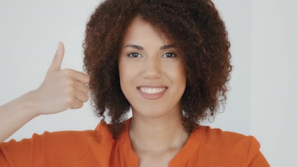 Usmívající se veselá Afroameričanka šťastná žena s kudrnatým účesem ukazující palec nahoru při pohledu na kameru těší pozitivní zpětnou vazbu hrdý vítěz ženská ruka znamení gesto doporučit nejlepší výběr práce. Vysoká - Záběry, video
