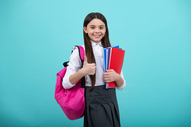 Back to school. Teenager school girl hold book and copybook ready to learn. School children with school bag on isolated blue studio background - Fotoğraf, Görsel