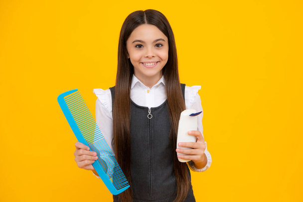 Teenager child girl showing bottle shampoo conditioners or shower gel. Hair cosmetic product. Bottle for advertising mock up copy space - Fotoğraf, Görsel