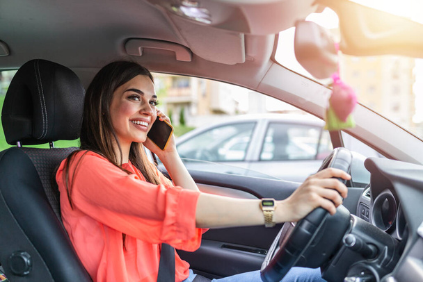 Businesswoman driving car and talking on cell phone concentrating on the road. Driving while holding a mobile phone cell phone use while driving. Woman In Car Talking On Mobile Phone Whilst Driving - Фото, изображение