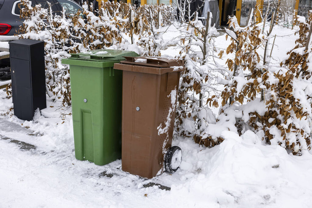 Close up view of house mail post box and waste and recycling containers on snowy bushes background. Sweden.  - Φωτογραφία, εικόνα