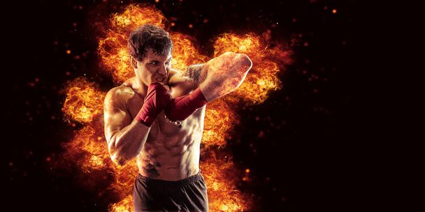 Fighter man punching in fire. MMA fighter. - Fotó, kép