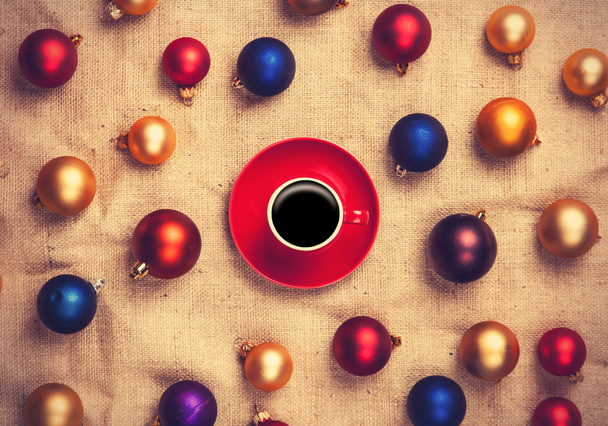 Hot coffee and christmas balls on jute background.  - Foto, Bild