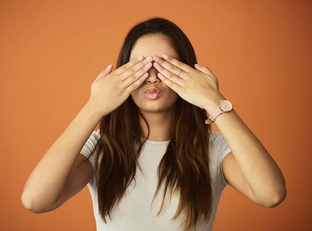 Behind closed eyes. an attractive young woman posing in studio against an orange background - Photo, image