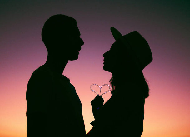My heart is yours. an affectionate young couple silhouetted at sunset - 写真・画像