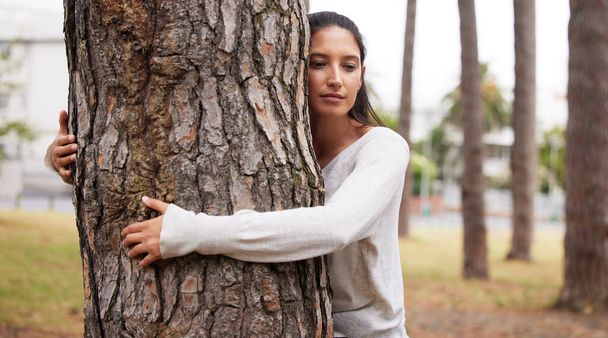 Объятия на века. молодая женщина обнимает дерево в парке - Фото, изображение