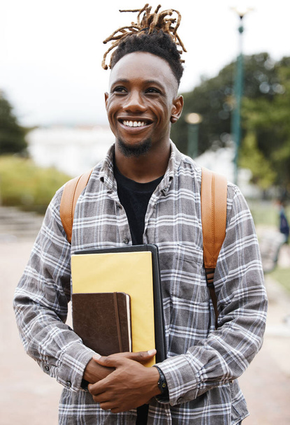 Education is the key to success. a young man holding books on campus - Photo, image