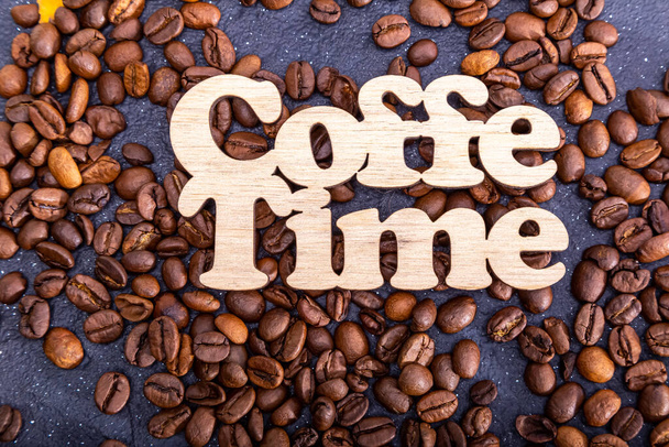 Текстура фону кавових зерен для дизайну з написом час кави. Кавові зерна розкидані на столі
. - Фото, зображення