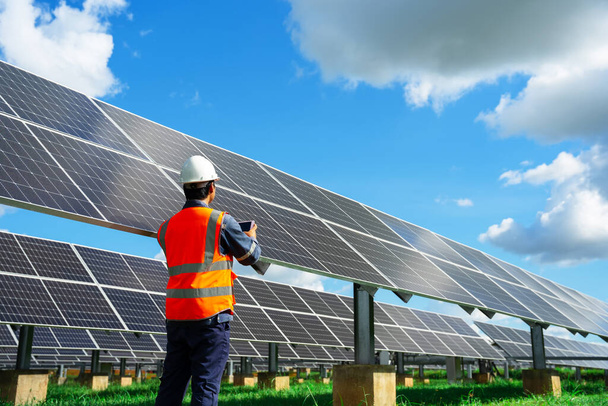 Teknisyenler güneş enerjisi santrali ekipmanlarının tam kapasitede çalışabilmesi için çalışmalarını kontrol ediyorlar. Dünyanın enerjisini korumak için alternatif enerji.. - Fotoğraf, Görsel