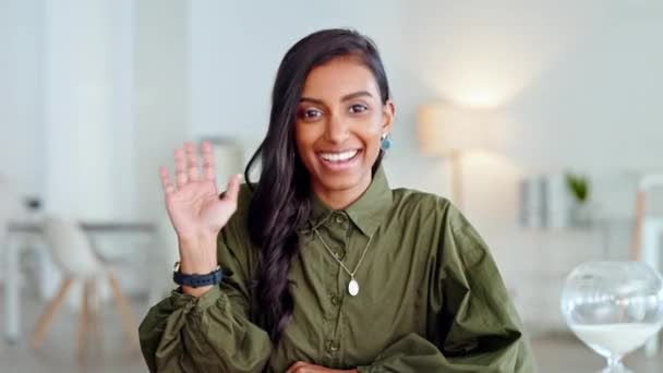 Young business woman waving hand and greeting on a videocall or zoom meeting while sitting in an office. Portrait of a beautiful and elegant female entrepreneur waves her palm on a virtual conference. - Filmagem, Vídeo