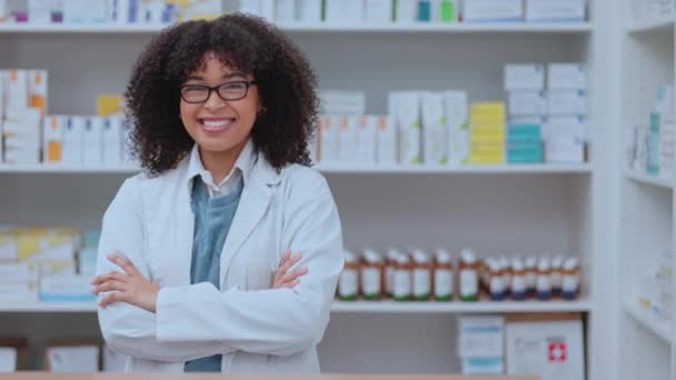 Proud, confident and happy pharmacist smiling while standing in a drugstore or pharmacy with copy space. Portrait of satisfied African female healthcare professional with a smile at a dispensary. - Video