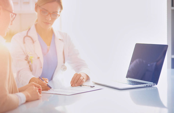 Doctor and patient couple are discussing something,sitting on the desk - Foto, Imagen