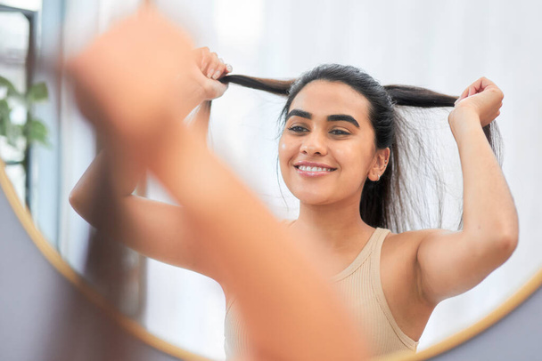 Put your hair in a ponytail and get ready to slay. a woman smiling while looking in the bathroom mirror - Fotografie, Obrázek