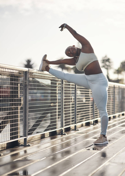 Dont forget to stretch daily. a young woman stretching on a footbridge - Foto, Imagem
