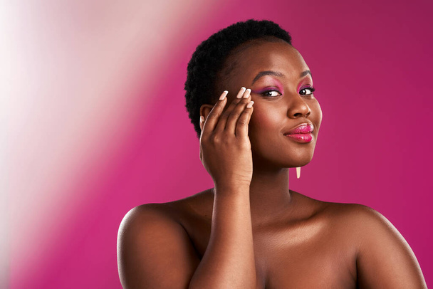 Oozing confidence. Studio shot of a beautiful young woman posing against a pink background - Foto, immagini