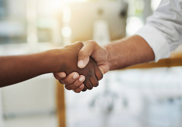 A team handshake in agreement between colleagues and coworkers in an office. Working together as a team to achieve success, merge as a partnership or promote a business person at work closeup. - Photo, Image