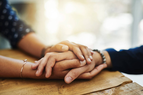 Holding hands, support and comfort of two people talking through a difficult problem. Closeup of friends showing care and love through a hard time, consoling each other and bonding. - Foto, imagen