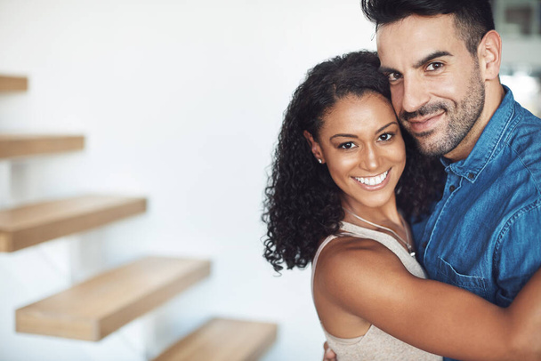 Hugging, love and affection couple loving, happy and smiling. Interracial boyfriend and girlfriend bonding together, dating and feeling positive. Portrait of cheerful married man and woman embracing. - 写真・画像