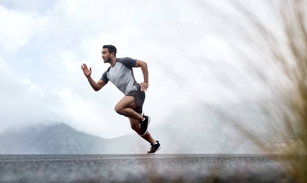 Champions know how to push through. a sporty young man running outdoors - Fotoğraf, Görsel