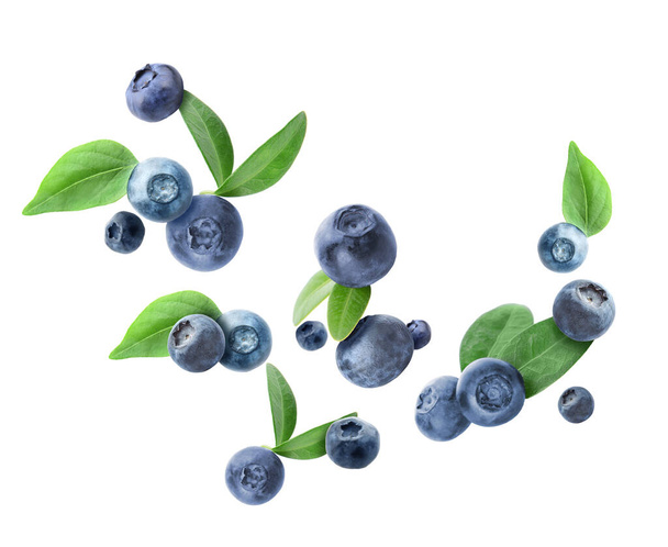 Many flying blueberries on white background - Photo, Image