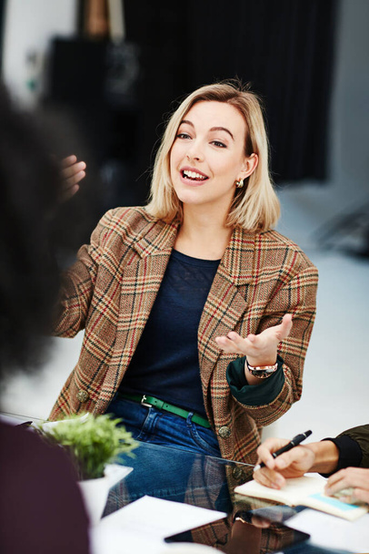 Confident, trendy and smiling businesswoman talking in meeting sharing her creative marketing ideas. Stylish team leader having a friendly staff discussion about project plans and job task management. - Фото, зображення