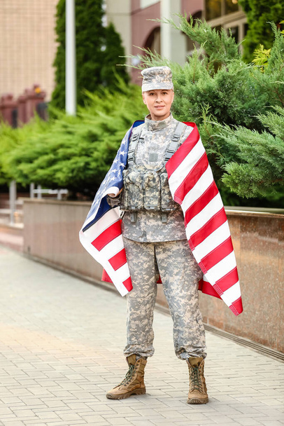 Mature female soldier with USA flag outdoors - Fotó, kép