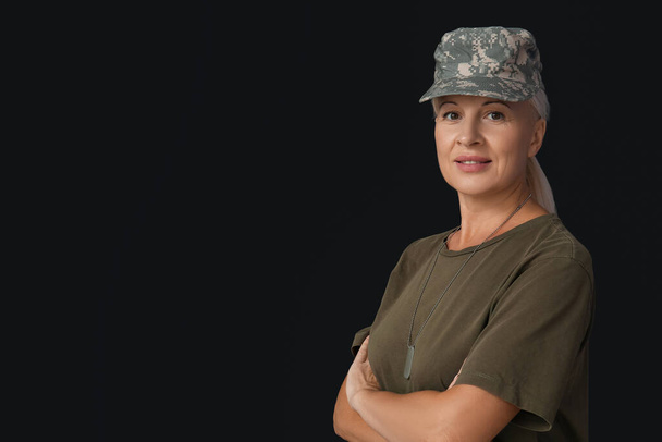Mature female soldier on black background - Foto, Bild